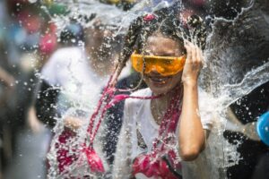 A woman reacts as a bucket of water is splashed on her during the Songkran water festival to celebrate the Thai New Year in Prachinburi Province, Thailand, Saturday April 13, 2024. It's the time of year when many Southeast Asian countries hold nationwide water festivals to beat the seasonal heat, as celebrants splash friends, family and strangers alike in often raucous celebration to mark the traditional Theravada Buddhist New Year.